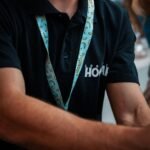 a man wearing a black shirt and a blue lanyard around his neck